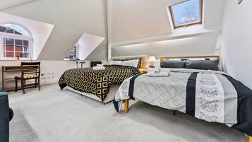 Un dormitorio con dos camas, un escritorio y una silla.