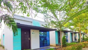 Un bâtiment moderne doté d’un toit plat, d’une porte bleue et d’un petit espace porche.