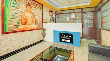 Un área de recepción con una estatua de Buda, un letrero azul y una vitrina de vidrio.