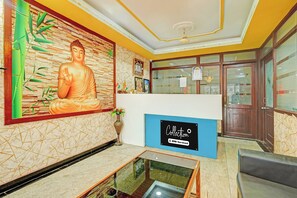 Un área de recepción con una estatua de Buda, un letrero azul y una vitrina de vidrio.