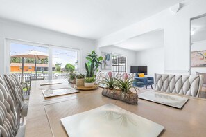 Una sala moderna con comedor, ventanas amplias y vistas al exterior.
