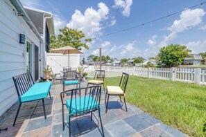 Eine Terrasse mit Gartenmöbeln und einem weißen Zaun.