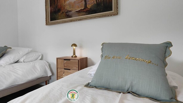 A bedroom with two beds, a nightstand with a lamp, and a painting on the wall. - La Grange d'Evelyne 4**** (DIZIMIEU)