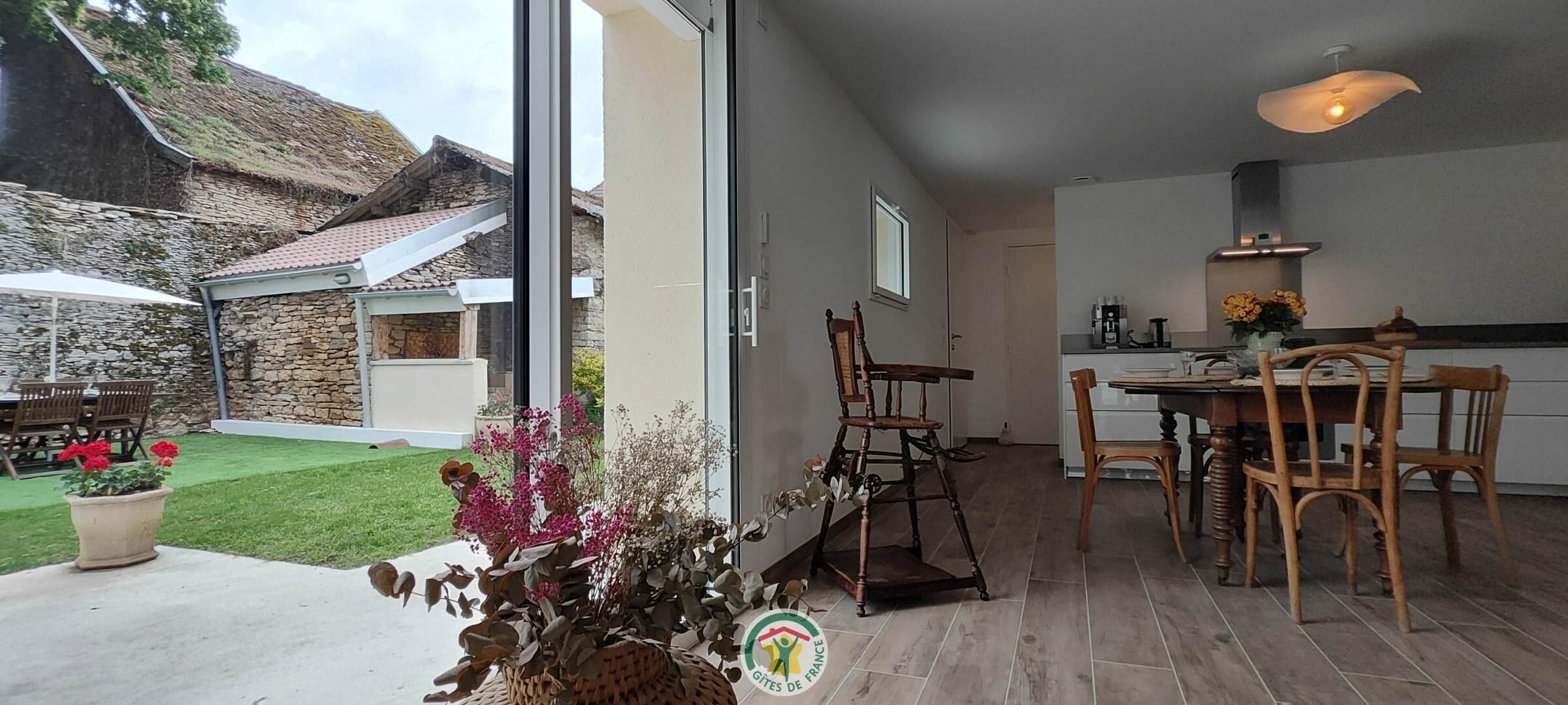 A modern kitchen with wooden furniture and a dining area with a table and chairs.