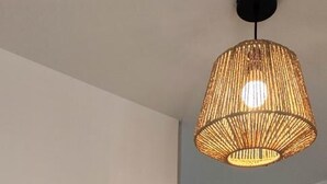 A room with a white dresser, a hanging wicker lamp, and a wooden wall decoration. - La Grange d'Evelyne 4**** (DIZIMIEU)