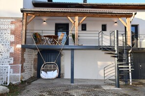 A modern building with a balcony, a swing chair, and a spiral staircase. - Domaine des Étoiles - Lovers' Cottage (GILLONNAY)
