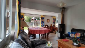 Una sala de estar con sofá, mesa de comedor y televisor.