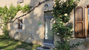 A rustic building with a stone facade, a wooden door, and a small window.