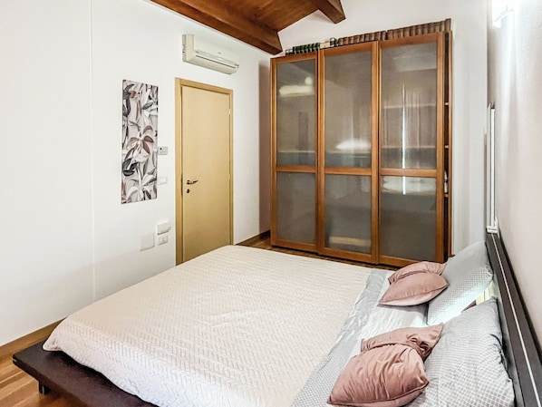 Un dormitorio con cama, armario y puerta.