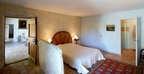 A bedroom with a bed, bedside lamps, a wooden headboard, a door, and a patterned rug. - Gaillard Farm - LANS EN VERCORS (LANS EN VERCORS)
