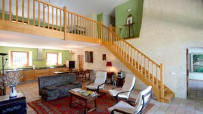 A spacious living area with a high wooden staircase, a dining area, and a kitchen. - Gaillard Farm - LANS EN VERCORS (LANS EN VERCORS)