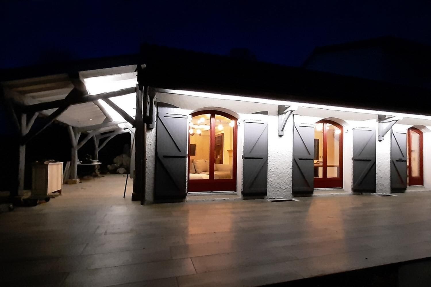 Un espace extérieur abrité, doté de plusieurs portes et d’une source de lumière qui éclaire l’ensemble.