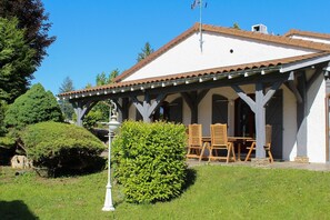 A building with a covered patio area, outdoor seating, and a well-maintained garden. - MY FATHER'S ESTATE - THE BEAUVOISIN BRIDGE (LE PONT DE BEAUVOISIN)
