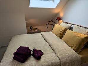 A bedroom with a bed, pillows, a bedside table, a lamp, and a skylight. - From Combeloup - MURIANETTE (MURIANETTE)