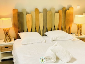 A hotel room with a bed, two bedside tables, and a headboard with wooden planks. - The Fishermen's House (VIGNIEU)