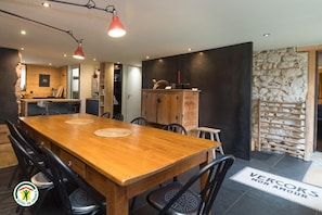 A dining area with a wooden table, black chairs, and pendant lights. - The Two Brothers' Farm (AUTRANS MEAUDRE EN VERCORS)
