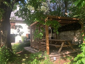 A wooden pergola structure with a stone wall in the background. - The Two Brothers' Farm (AUTRANS MEAUDRE EN VERCORS)