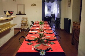 A dining area with a long table set for a meal, chairs, a buffet counter, and a decorative wall. - The Plantier Estate Guesthouse (SAINT HILAIRE DE LA COTE)