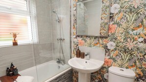 A bathroom with a glass-enclosed shower, a white pedestal sink, and a toilet. - Acorn Cottage (Yarm)