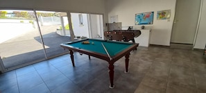 A pool table in a room with a view of the outside. - Gite de la Manonière - 4**** (SAINT DIDIER DE LA TOUR)