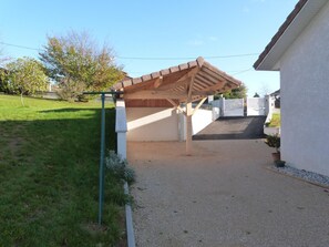 A covered outdoor area with a gravel path leading to a white building. - Gite de la Manonière - 4**** (SAINT DIDIER DE LA TOUR)