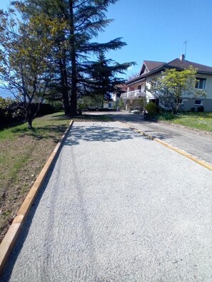 Une rue résidentielle bordée de maisons, avec un ciel dégagé et une route en gravier.