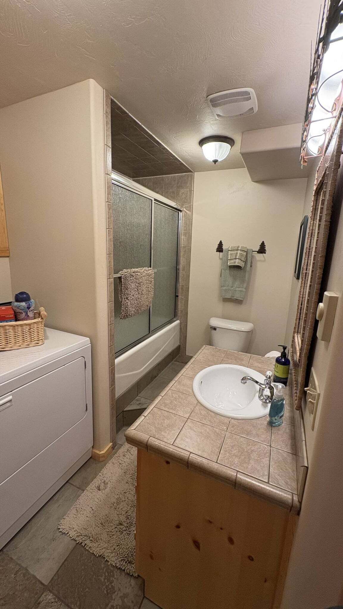 Un baño con bañera, inodoro, lavamanos y ducha.