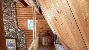 A wooden interior with a stone wall and a framed picture. - Sagebrush Meadows+Hotub+WiFi+20minsYellowstone (Island Park)