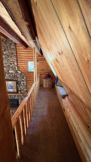 A wooden interior with a stone wall and a framed picture. - Sagebrush Meadows+Hotub+WiFi+20minsYellowstone (Island Park)