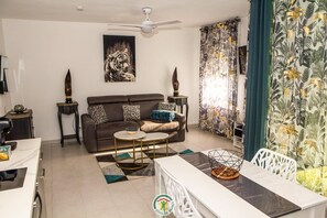 Ein Wohnzimmer mit einer Couch, einem Couchtisch und einem Tigerbild an der Wand.