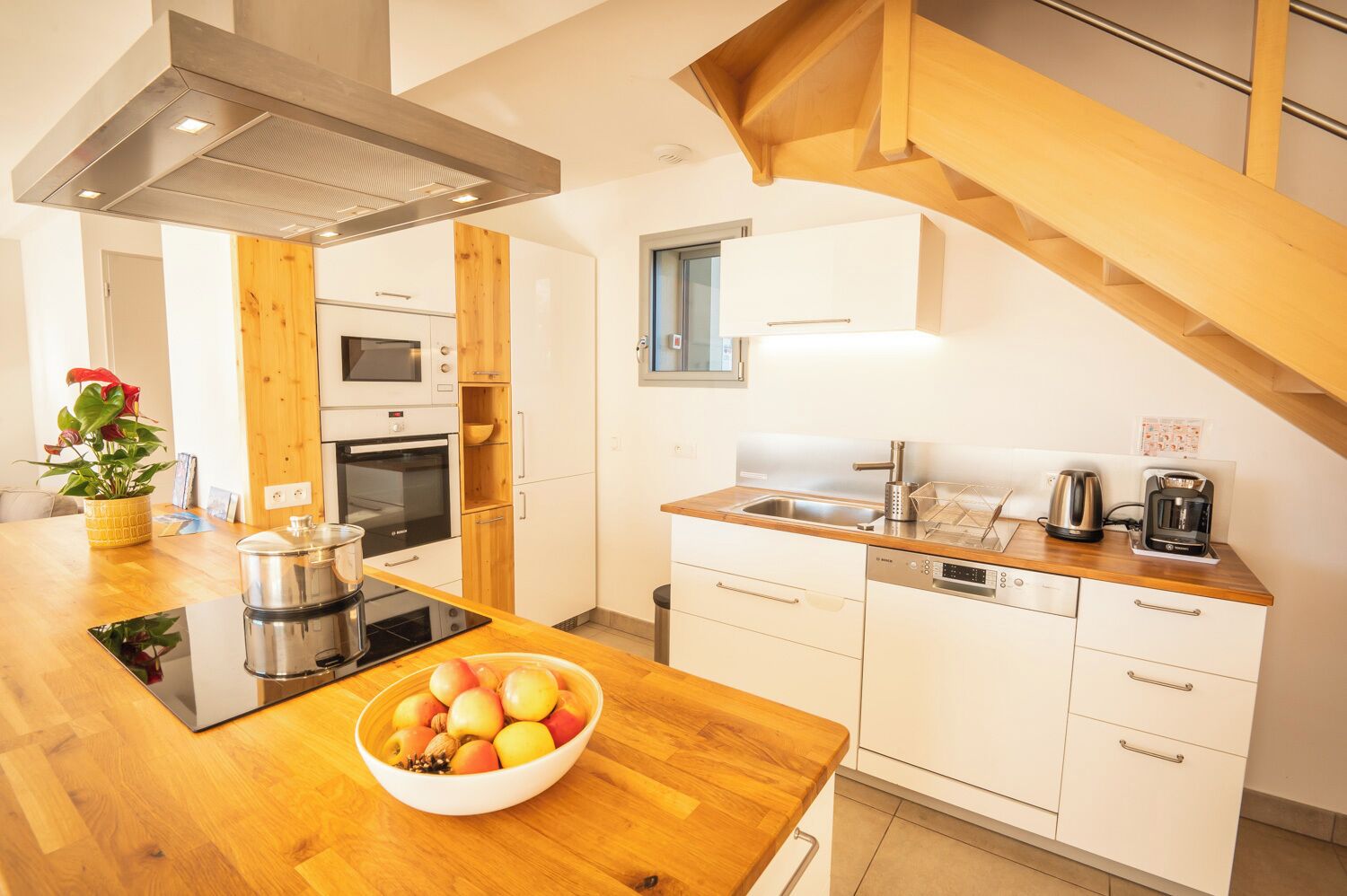 A modern kitchen with wooden cabinets, a stainless steel sink, and a built-in oven.