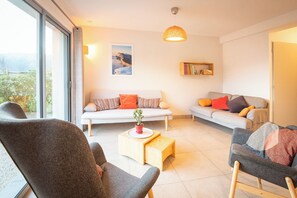 Ein modernes Wohnzimmer mit zwei Sofas, einem Couchtisch und einem Bücherregal.