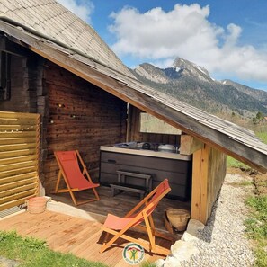 A rustic wooden cabin with a sloped roof, a small kitchenette, and two wooden chairs. - Le Maz'eau - 4**** - SAINT PIERRE DE CHARTREUSE (SAINT PIERRE DE CHARTREUSE)