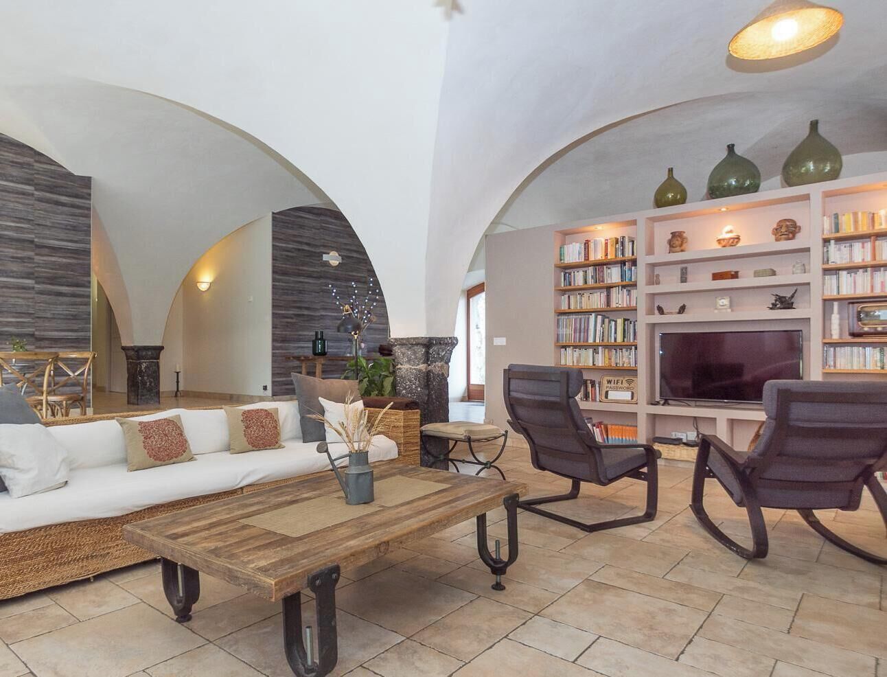 Un salon moderne comprenant un canapé, des fauteuils, une table basse et une bibliothèque.