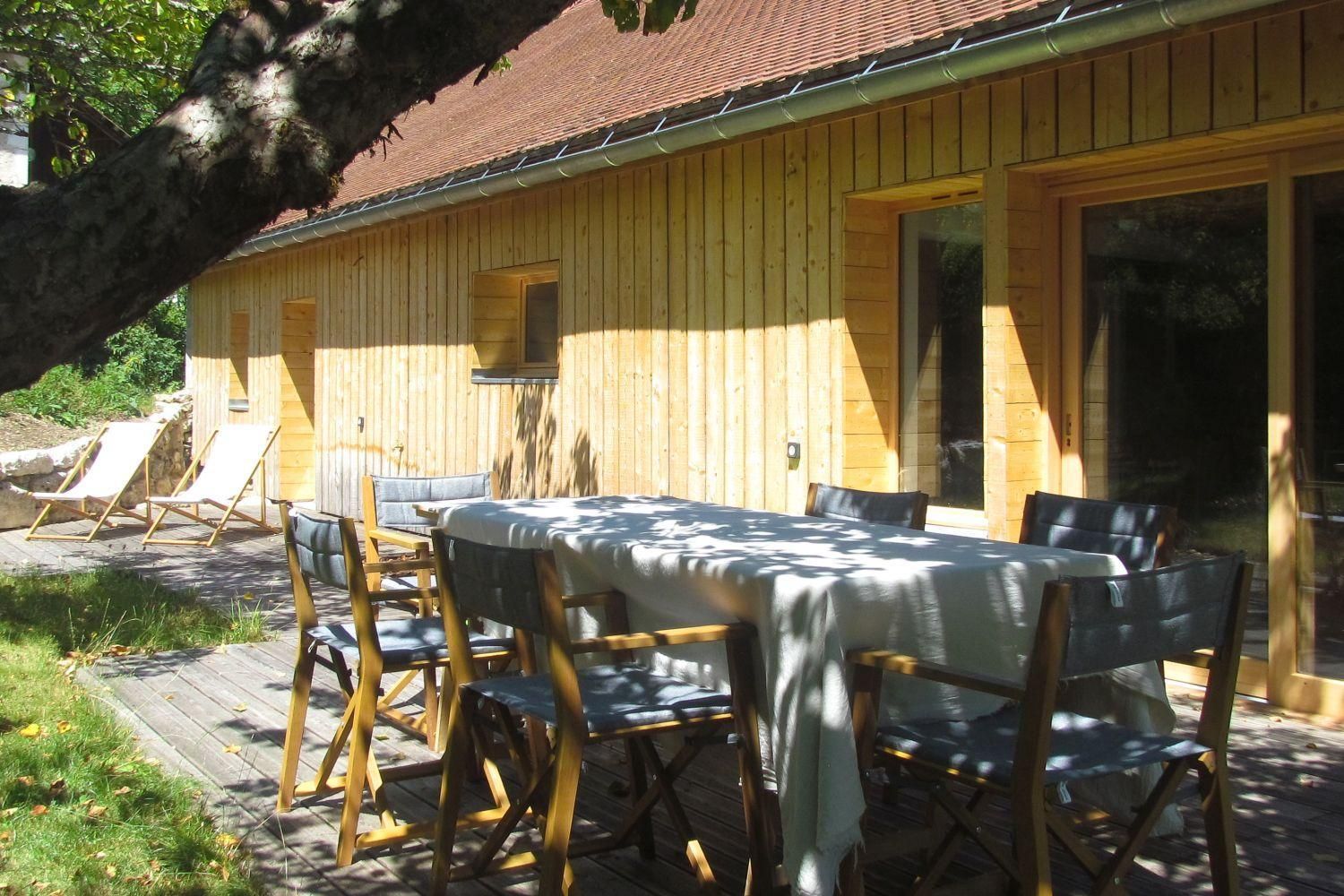 A wooden cabin with a dining table and chairs, a window, and a door.