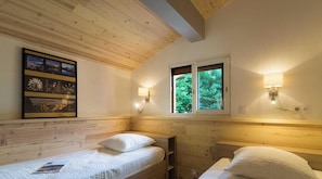 A room with two beds, wooden ceiling beams, a framed picture on the wall, and two wall-mounted lamps. - L'Orchis - VALJOUFFREY (VALJOUFFREY)