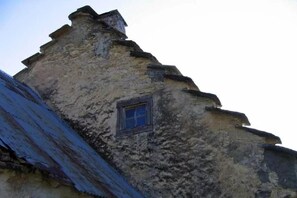 Ein Gebäude mit einem steilen Dach und einem kleinen Fenster.