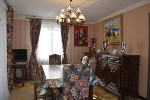 A room with a dining table, chairs, a chandelier, a television, and artwork on the walls. - At the Japanese Spring - 4**** (PIERRE CHATEL)