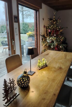 A dining area with a wooden table, chairs, a lamp, a small Christmas tree, and a decorative globe. - The 12 Summits - PONSONNAS (PONSONNAS)