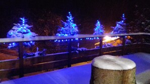 A snow-covered outdoor area with a railing and snow-covered trees. - Marameille Chalet (ALLEVARD)