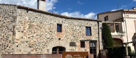 A stone building with a sign for 'Hotel Mol Cardedeu' indicating a traditional architectural style.