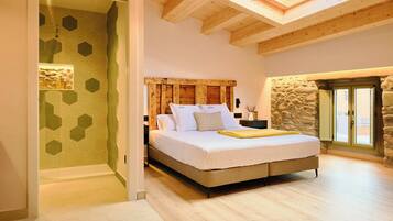 A bedroom with a skylight, a stone wall, and a bed with a wooden headboard.