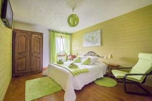 A bedroom with a bed, a chair, a desk, a wardrobe, and a painting on the wall. - L'Écoline 5-Star Vacation Rental (BRION)