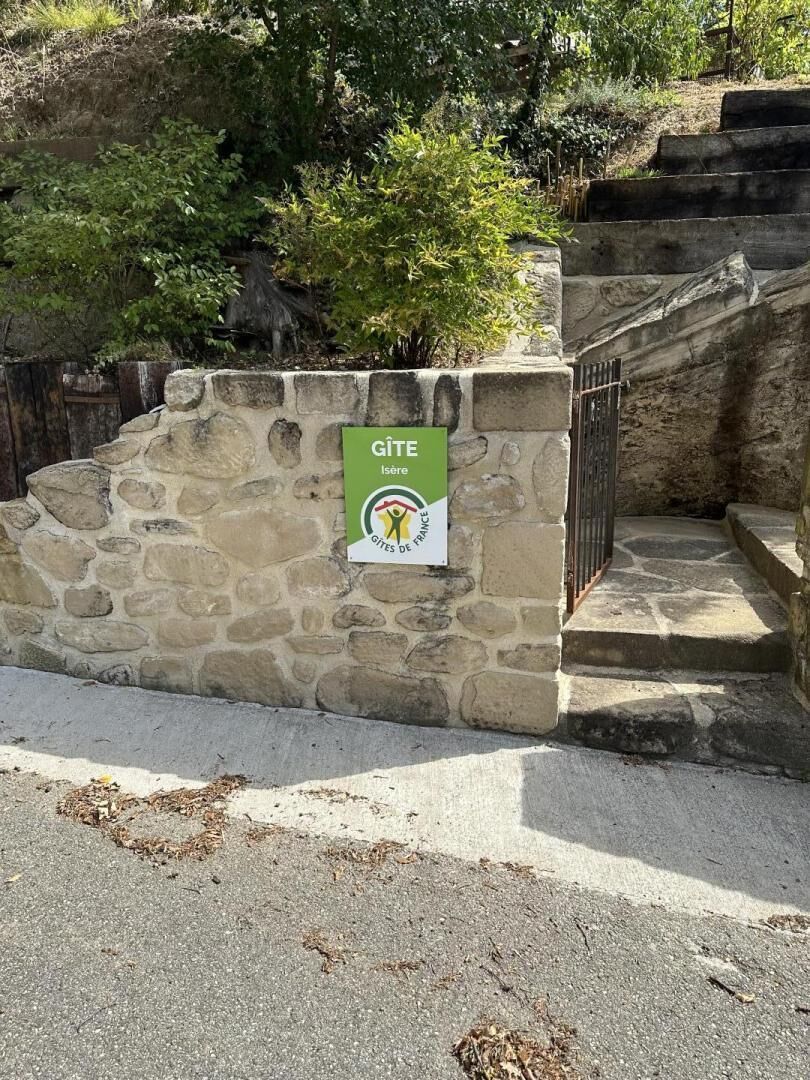 Una pared de piedra con un letrero que dice 'GITE Isere Gites de France'.