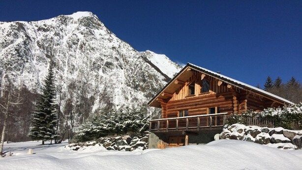A wooden cabin with a balcony, surrounded by snow-covered mountains and trees. - CHANTELOUVE / LE BECAN (CHANTEPERIER)