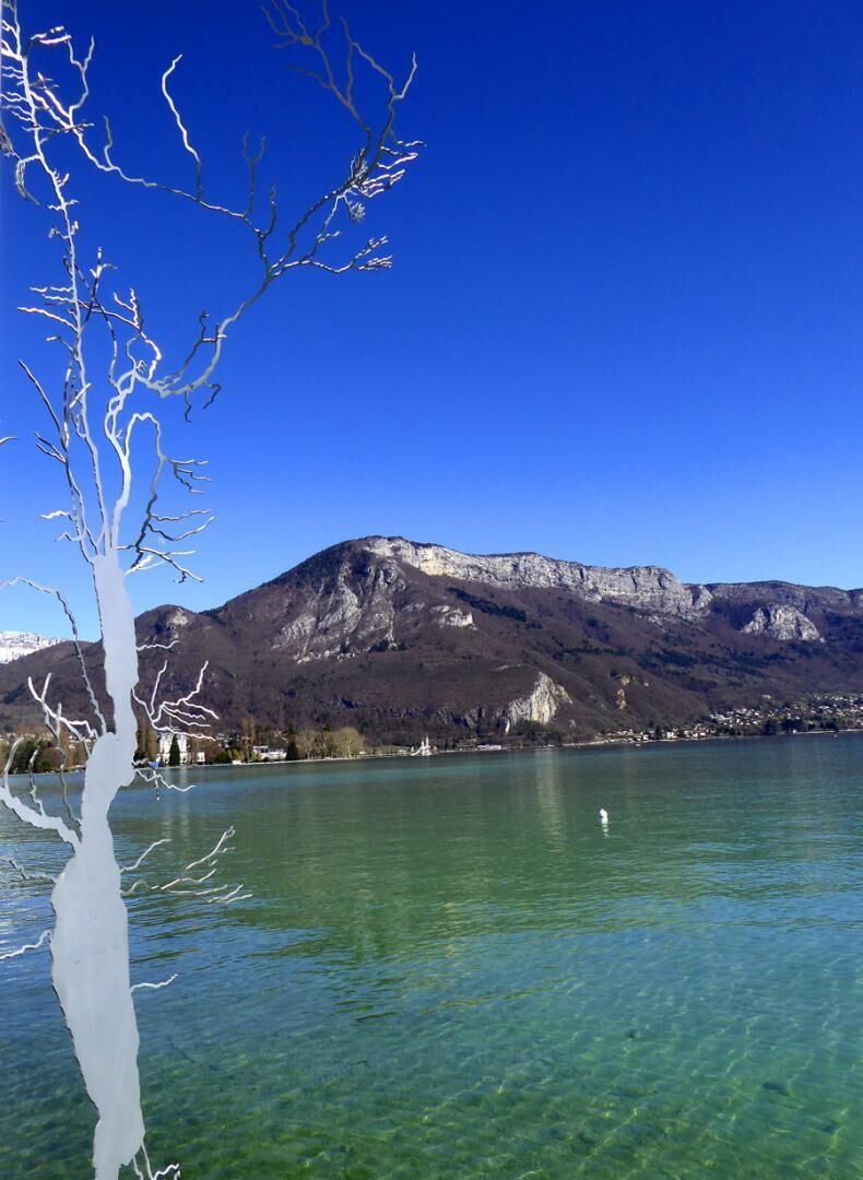 A clear lake with mountains in the background.