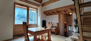 Ein Holzinterieur mit Esstisch, Stühlen und einer Treppe.