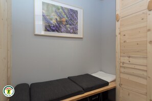 Ein Zimmer mit einem Bett, einem gerahmten Bild an der Wand und einer Holztür.
