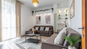 Een moderne woonkamer met een bank, salontafel en een kroonluchter.