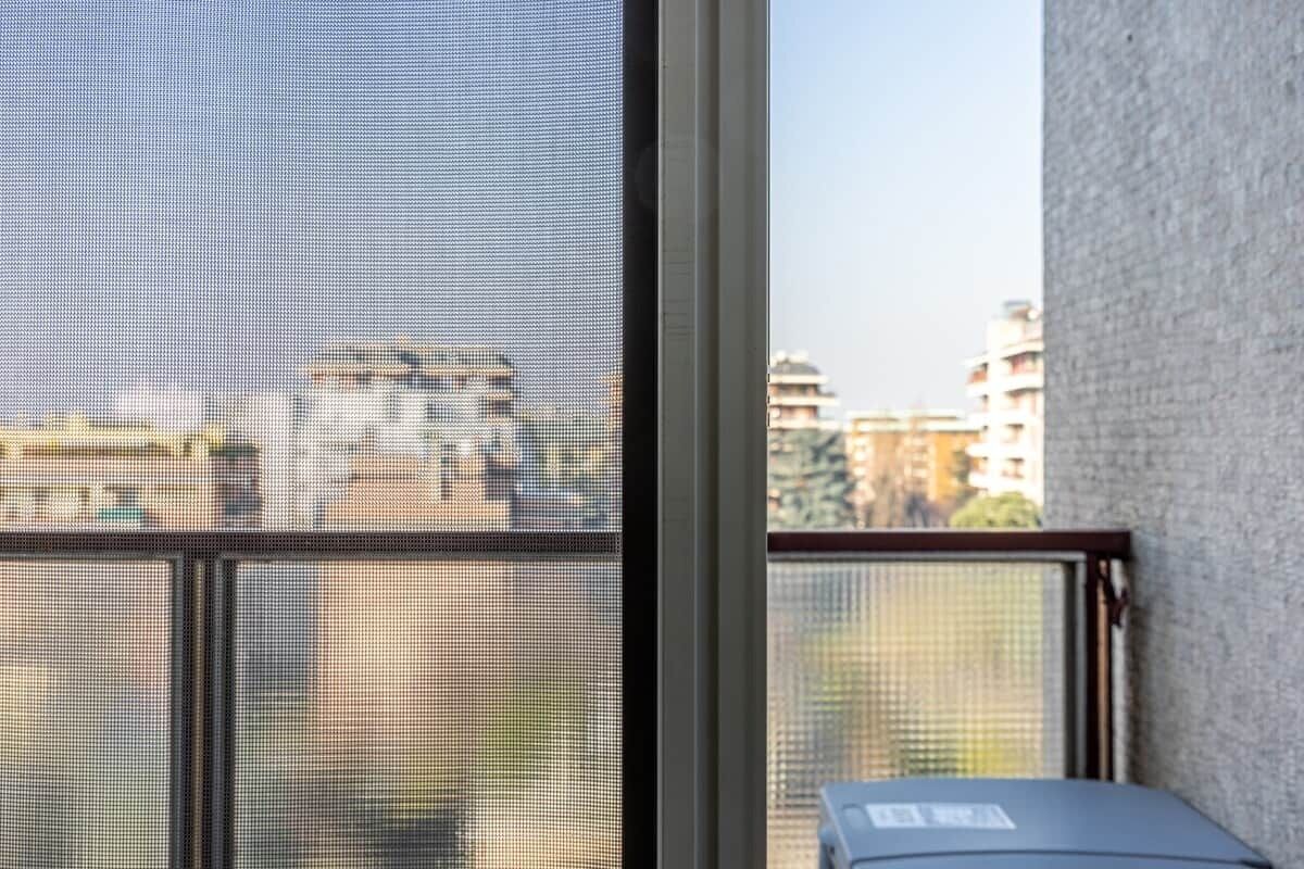 Una stanza con una grande finestra che si affaccia su un panorama urbano.